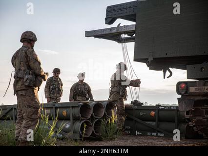 Soldaten des 1-147. Field Artillery Regiment, South Dakota Army National Guard laden Reduced-Range-Übungsraketen in das M270A1 Multiple Launch Rocket System in Camp Ripley, Minnesota, 19. Juli 2022. Die Soldaten starteten die Raketen im Rahmen ihrer jährlichen Ausbildung, um die Besatzungen für die Rotation nach vorne zu zertifizieren. Stockfoto