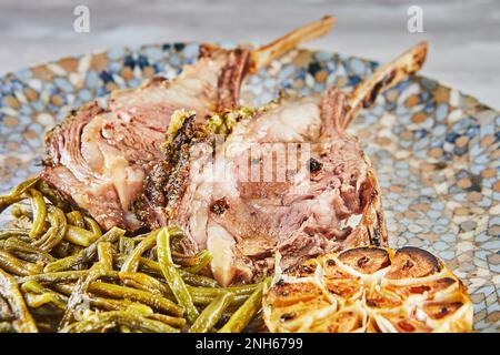 Lammriegel, mittelgroß, gebacken mit grünen Bohnen und Knoblauch Stockfoto