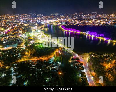 Fesselnder Blick bei Nacht auf den Xuan Huong See in Da Lat City, Vietnam: Die perfekte Mischung aus Stadtlicht und ruhigem Wasser Stockfoto