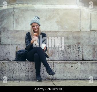 Ihre klügste Verbindung zu ihrem sozialen Kreis. Eine attraktive Frau, die ein Handy in der Stadt benutzt. Stockfoto