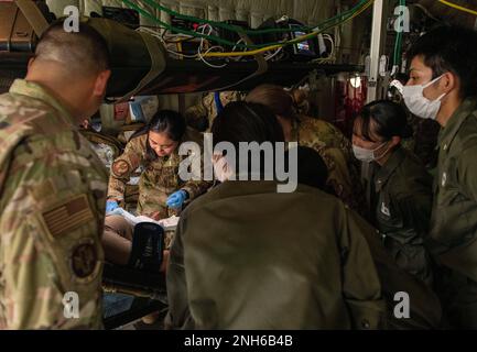 Studenten und Ausbilder des National Defense Medical College beobachten, wie Senior Airman Princess Bagay, 18. Aeromedical Evacuation Squadron Technician, simulierte Patientenbehandlung in einem C-130J Super Hercules während einer japanischen Nursing Student Immersion am 19. Juli 2022 auf der Yokota Air Base, Japan demonstriert. Die 374. Medical Group hielt ihre erste japanische Krankenpflegeschüler-Immersion ab und präsentierte praktische Erfahrungen mit der Militärkrankenpflege und Erlebnisbereitschaft-Training in mehreren Krankenpflegebereichen. Stockfoto