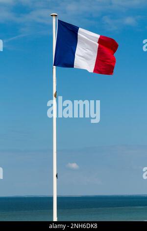 Schöne französische Flagge am blauen Himmel und Ozean Stockfoto