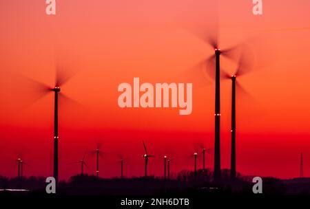 07. Februar 2023, Mecklenburg-Vorpommern, Bützow: Die Rotoren der Windturbinen drehen sich nach Sonnenuntergang. (Long Exposure shot) die Landesregierung von Mecklenburg-Vorpommern möchte die Ausweitung der Windenergie durch einheitliche Regeln für die Ausweisung geeigneter Gebiete fördern. Foto: Jens Büttner/dpa Stockfoto