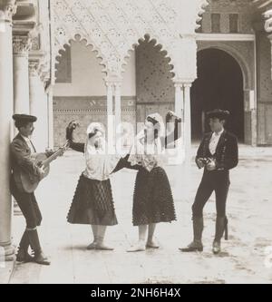 Kultur des alten Spaniens. Spanische Tänzer im Alcazar, Sevilla, Spanien. 1908 das Königliche Alcázars von Sevilla (Spanisch: Reales Alcázares de Sevilla), historisch bekannt als al-Qasr al-Muriq und allgemein bekannt als Alcázar von Sevilla, ist ein Königspalast in Sevilla, Spanien, erbaut für den christlichen König Peter von Kastilien. Es wurde von kastilischen Christen auf dem Gelände einer abbadierten muslimischen alcazar oder einer Wohnfestung erbaut. Stockfoto