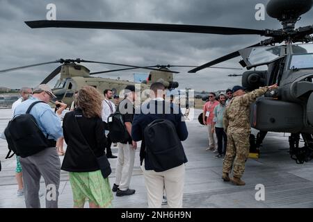 Chief Warrant Officer 4 Jason Plonka, rechts, AH-64 Apache Helikopter Pilot, 12. Combat Aviation Brigade, diskutiert die Fähigkeiten der AH-64 mit Teilnehmern der Farnborough International Airshow in Farnborough, Großbritannien, am 20. Juli 2022. Die Flugschau dient als globale Plattform für die Luft- und Raumfahrt- und Verteidigungsindustrie. 12. Combat Aviation Brigade ist eine der Einheiten, die die USA unterstützen Die Strategie des europäischen Kommandotheaters, indem das Engagement der USA für europäische Verbündete und Partner unter Beweis gestellt und die Fähigkeiten der USA für unterschiedliche Zielgruppen hervorgehoben werden. 12 CAB gehört zu den Einheiten des V Corps, Amerikas F Stockfoto