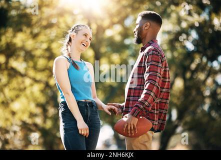 Paare, American Football im Park und glücklich zusammen, Sommer mit Hand-Halten im Freien und Sport in der Sonne. Engagement, Vertrauen und Fitness, schwarzer Mann Stockfoto