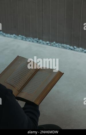 Islamisches vertikales Foto. Muslimischer Mann, der den Heiligen Koran in einer Moschee liest. Hintergrundfoto der Ramadan-Konzeptgeschichte. Istanbul Turkiye - 11.12.2022 Stockfoto