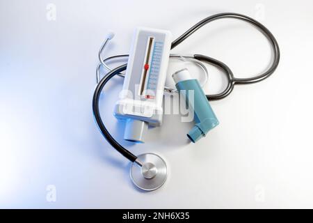 Medizinische Geräte für Asthma, Allergie und COPD, Peak Flow Meter, Inhalator Pumpspray und ein Stethoskop auf weißem Hintergrund, hohe Sicht von oben, Stockfoto