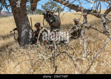 USA Soldaten der Bravo Kompanie zugeteilt, 1. Bataillon, 23. Infanterie-Regiment, 2. Stryker-Brigaden-Kampfteam, 2. Infanterie-Division, bietet Basisfeuer, um ein Flankiermanöver gegen Alpha-Kompanie abzudecken, 1. Bataillon, 297. Infanterie-Regiment, 29. Infanteriebrigade-Kampfteam aus Alaska als gegnerische Kräfte während des XCTC-Programms (Exportable Combat Training Capability) in Camp Roberts, Kalifornien, 20. Juli 2022. XCTC konzentriert sich auf vollständig instrumentelle und realistische kollektive Schulungen, um die Kenntnisse auf Platoon- und Unternehmensebene zu zertifizieren. Stockfoto