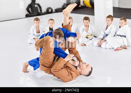 Lehrer, Profi-Judo, Jiu Jitsu-Trainer-Trainingstypen, Jungs, zeigen Übungen. Aufmerksamkeit, Kraft, Ausdauer Stockfoto