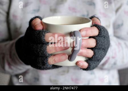 Senioren halten Tasse mit heißem Getränk Stockfoto