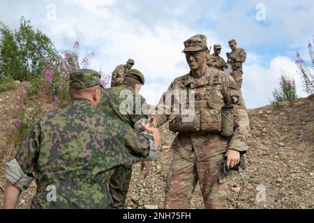 USA Armeekapitän Eric Cruz, Kommandeur der ‚Viper‘ Company, 1. Bataillon, 26. Infanterieregiment, 2. Brigaden-Kampfteam, 101. Luftangriff, begrüßt Oberstleutnant Jussi Annala, Stabschef der Jaeger-Brigade, zu Beginn einer kombinierten Lageübung in Sodankyla, Finnland, 20. Juli 2022. Der 2. BCT ist der 101. Luftwaffendivision (Air Assault) zugewiesen und steht unter dem Kommando und der Kontrolle von V Corps, Amerikas vorderster Truppe in Europa, die mit NATO-Verbündeten und regionalen Sicherheitspartnern zusammenarbeitet, um glaubwürdige Kampfkräfte zur Verfügung zu stellen. Stockfoto