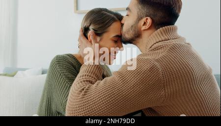 Liebe, Unterstützung und Zufriedenheit mit einem Paar zu Hause, das einen intimen Moment mit einem Kuss teilt. Lächeln, reden und Romantik mit einem jungen Mann und Stockfoto