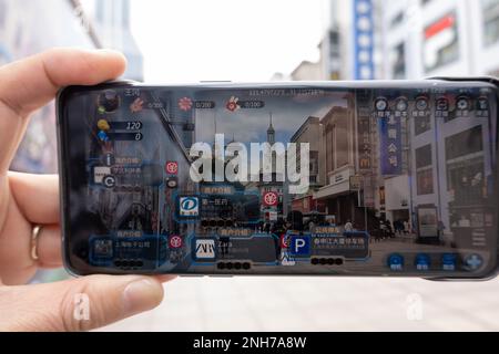 SHANGHAI, CHINA - 21. FEBRUAR 2023 - Ein Tourist verwendet die App „Play Nanbujie“ auf der Nanjing Road Pedestrian Street in Shanghai, China, 21. Februar 2023. Stockfoto