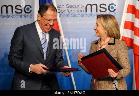 EINGEREICHT am 04. Februar 2011, Bayern, München: Damals-USA Staatssekretärin Hillary Clinton und russischer Außenminister Sergei Lavrov tauschen auf der 47. Sicherheitskonferenz in München Verträge über die neue Startvereinbarung aus. Das neue Abkommen zwischen den USA und Russland ist das umfassendste nukleare Abrüstungsabkommen seit zwei Jahrzehnten. Der russische Präsident Putin hat die Aussetzung des letzten großen nuklearen Abrüstungsvertrags mit den Vereinigten Staaten angekündigt. Dies ist kein Ausstieg, sondern eine Aussetzung des "New Start"-Vertrags, sagte der Kreml-Führer am Dienstag in Moskau. Foto: Bildallianz Stockfoto