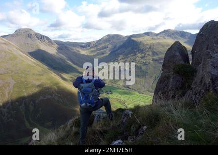 Man (Hiker) fotografiert die Wainwrights, Great Gable, Lingmell und die Scafell Mountain Range von Stirrup Crag auf Yewbarrow, Wasdale Head, Stockfoto