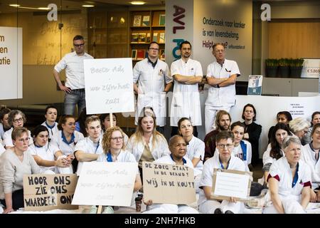 AMSTERDAM - Angestellte des Antoni van Leeuwenhoek Krankenhauses sitzen auf dem Boden als Aktion für einen besseren Tarifvertrag. Die Klage steht in Zusammenhang mit dem Ultimatum der Gewerkschaften. Sie wollen, dass der niederländische Krankenhausverband ihren Forderungen nachkommt, einen Streik zu verhindern. ANP EVA PLEVIER niederlande raus - belgien raus Stockfoto