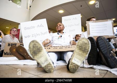 AMSTERDAM - Angestellte des Antoni van Leeuwenhoek Krankenhauses sitzen auf dem Boden als Kampagne für einen besseren Tarifvertrag. Die Maßnahme ist mit dem von den Gewerkschaften festgelegten Ultimatum verbunden. Sie wollen, dass der niederländische Krankenhausverband ihren Forderungen nachkommt, einen Streik zu verhindern. ANP EVA PLEVIER niederlande raus - belgien raus Stockfoto