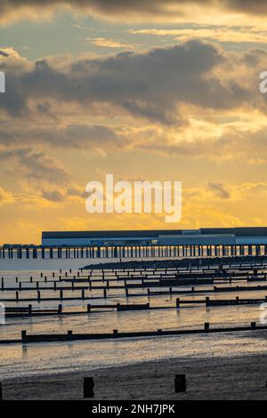 Der Strand und Pier bei Sonnenuntergang in Walton on the Naze Stockfoto