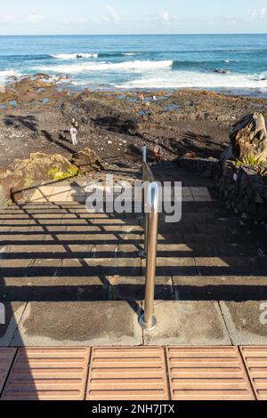 Stufen hinunter zum schwarzen Sandstrand von Playa Jardin puerto de la cruz und zum Atlantischen Ozean. Natürliche, halbabstrakte Muster Stockfoto