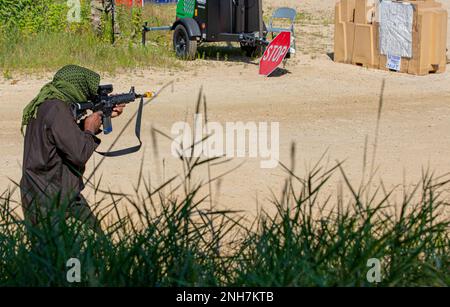 Ein Soldat von der 231. Transportation Company, der die Rolle eines Mitglieds der Oppositionstruppe spielt, überfällt die Soldaten, die während der Abwehr am 22. Juli 2022 auf der taktischen Trainingsbasis Independence in Fort McCoy, Wisconsin, einen Eingang verteidigten. Diese Übung ist Teil der jährlichen WAREX, in der Einheiten der Army Reserve gemeinsame Schulungen im Rahmen der 78. Ausbildungsabteilung durchführen. Stockfoto