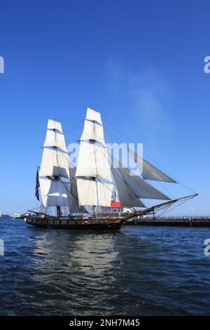 Großsegler, der vom Lake Superior in den Duluth Ship Canal eintrifft, mit dem Duluth South Breakwater Outer Light in Duluth, Minnesota, USA. Stockfoto