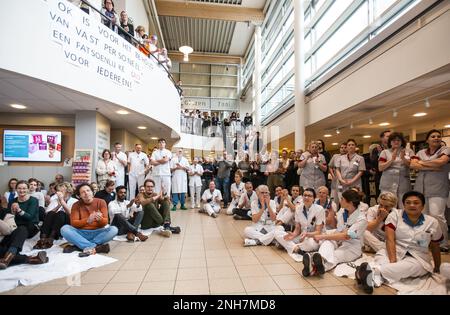 AMSTERDAM - Angestellte des Antoni van Leeuwenhoek Krankenhauses sitzen auf dem Boden als Kampagne für einen besseren Tarifvertrag. Die Maßnahme ist mit dem von den Gewerkschaften festgelegten Ultimatum verbunden. Sie wollen, dass der niederländische Krankenhausverband ihren Forderungen nachkommt, einen Streik zu verhindern. ANP EVA PLEVIER niederlande raus - belgien raus Stockfoto