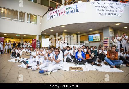 AMSTERDAM - Angestellte des Antoni van Leeuwenhoek Krankenhauses sitzen auf dem Boden als Kampagne für einen besseren Tarifvertrag. Die Maßnahme ist mit dem von den Gewerkschaften festgelegten Ultimatum verbunden. Sie wollen, dass der niederländische Krankenhausverband ihren Forderungen nachkommt, einen Streik zu verhindern. ANP EVA PLEVIER niederlande raus - belgien raus Stockfoto