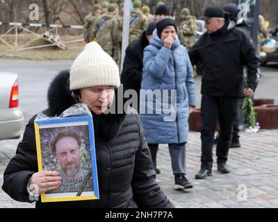 KIEW, UKRAINE - 21. FEBRUAR 2023 - Eine Frau hält das Portrait des Revolutionsaktivisten, ukrainischen Verteidigers Andrii Zahoruiko, der in der starb Stockfoto