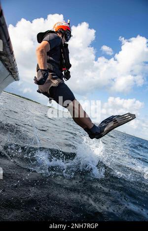 Ein Matrose, der dem Naval Aviation Schools Command in Pensacola, Florida, zugeteilt wurde, betritt das Wasser während einer Trainingsentwicklung in der Pensacola Bay während der Aviation Rescue Swimmer School am 21. Juli 2022. Die Schulung ist körperlich anstrengend und beinhaltet Unterweisung zu Themen wie Aufgaben und Aufgaben des fliegenden Personals, Überleben, erste Hilfe und Wasserrettungsverfahren. Mit diesen Fähigkeiten wird das einberufene Luftfahrtpersonal schließlich zu Flottengeschwadern entsandt, um die Schwimmschwimmer zu retten. Stockfoto