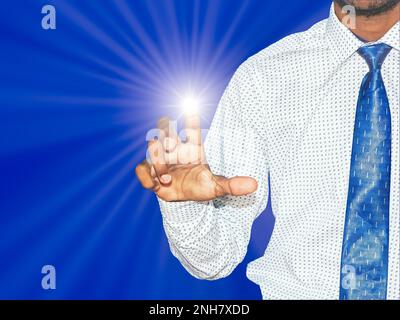 Junge indische Geschäftsmann auf Drücken der Taste auf dem virtuellen Bildschirm mit Lichtstrahl auf Blau farbigen Hintergrund. Für die Unterstützung der Technologie ar Stockfoto