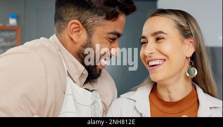 Ein junges Paar in der Küche, Leute kochen in der mexikanischen Wohnung und Comic-Indianer-Witz mit Freundinnen-Lächeln. Gesicht einer glücklichen Latino-Frau, die spricht Stockfoto