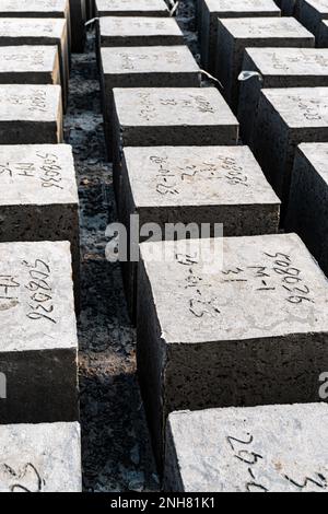 Hochformat des Betonwürfels über Blockhintergrund. Waghalsiger. Vier quadratische Betonblöcke hintereinander Stockfoto