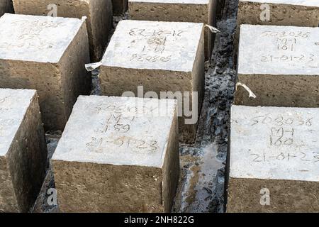 Waghalsiger. Vier quadratische Betonblöcke hintereinander Stockfoto