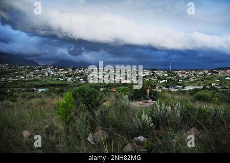 Gewitterwolken sammeln sich über einem afrikanischen Dorf, während Teile des Südostens Afrikas von extremen Wetterbedingungen heimgesucht werden Stockfoto