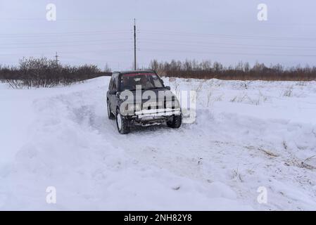 Offroad-Geländewagen „Suzuki Escudo“ fährt im Winter schnell auf einer verschneiten Straße. Stockfoto