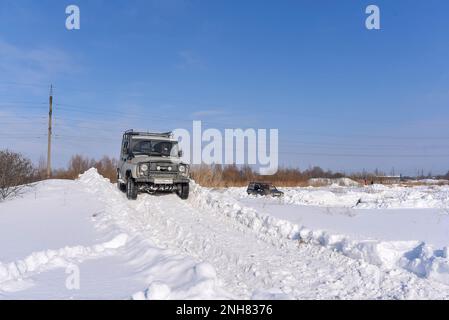 Der russische Offroad-SUV „UAZ Junter 469“ fährt im Geländewagen im Winter auf einem Feld auf einer schlechten Straße auf einem schneebedeckten Berg. Stockfoto