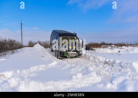 Offroad-SUV „Mitsubishi Delica“ 4x4 mit ungedrehtem Windenseil am Stoßfänger fährt im Winter schnell aktiv auf einer Schneerutsche. Stockfoto