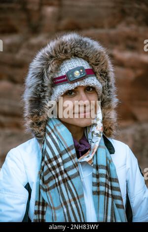 Wunderschöne Wanderin mit Stirnlampe, die für die Kälte gekleidet ist, während der Wanderung im Zion-Nationalpark, Utah Stockfoto