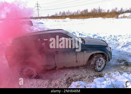 Off-Road-Auto „Suzuki Grand Vitara“ 4x4 aktiv und schnell in einem karmesinroten Rauch. Stockfoto