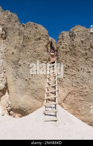 Frau, die von einer hölzernen Leiter zum Strand von Tsigrado geht, Milos Stockfoto