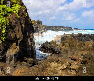 Wellen schlagen gegen die zerklüftete Lava Küste nahe Kauiau Point, Waianapanapa State Park, Maui, Hawaii, USA Stockfoto