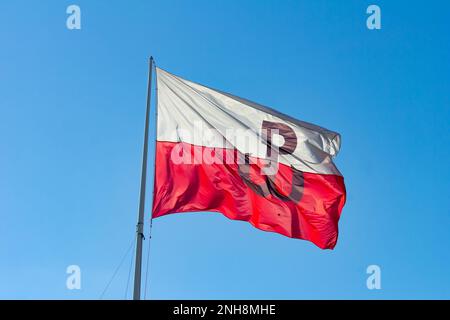 Flagge des polnischen Untergrundstaates (Polskie Panstwo Podziemne und Armia Krajowa), die in Polen im Wind mit blauem Himmel windet Stockfoto