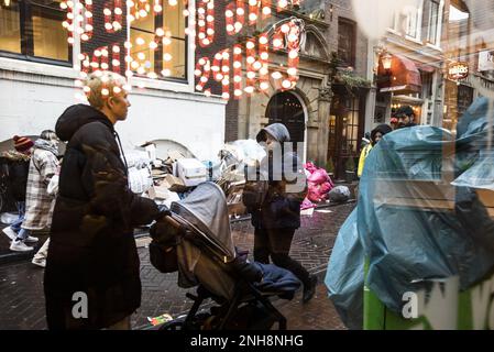 AMSTERDAM - Touristen gehen während eines Streiks von kommunalen Beamten, einschließlich Ermittlungsbeamten und Müllsammlern, am Müll vorbei, um einen besseren Tarifvertrag zu schließen. Sperrige Abfälle und Haushaltsabfälle werden während des Streiks nicht gesammelt. Die Straßen werden auch nicht geputzt, Mülleimer werden nicht geleert und Berichte über Müll auf der Straße werden nicht bearbeitet. ANP EVA PLEVIER niederlande raus - belgien raus Stockfoto