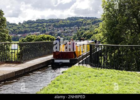 Ein Paar, das mit seinem schmalen Kanalboot am Eingang zum Pontcysyllte Aquädukt vom Trevor-Becken navigiert. Stockfoto