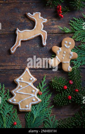 Foto von Weihnachtsmotiven, bestehend aus Teesüßen in Tierform und auf rustikalem Holzhintergrund Stockfoto