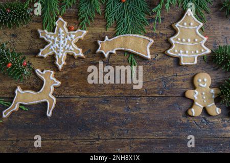 Foto von Weihnachtsmotiven, bestehend aus Teesüßen in Tierform und auf rustikalem Holzhintergrund Stockfoto