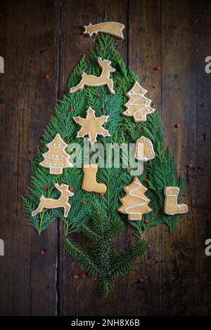 Foto von Weihnachtsmotiven, bestehend aus Teesüßen in Tierform und auf rustikalem Holzhintergrund Stockfoto