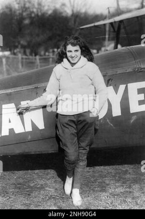 Lillian Boyer steht auf dem Flügel eines fliegenden Doppeldeckers, 21. Januar 1922. Lillian Boyer (1901-1989) war ein amerikanischer Wanderer, der zwischen 1921 und 1929 zahlreiche Stunts aus der Luft vorführte, darunter Flügelwandern, Transfers vom Auto zum Flugzeug und Fallschirmspringen. Stockfoto