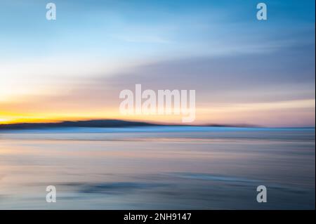 Die verschwommene Wirkung von Meereslandschaft am Abend. Naturlandschaft im Hintergrund der Ostsee in Lettland. Absichtliche Kamerabewegung, die einen traumhaften Hintergrund erzeugt Stockfoto